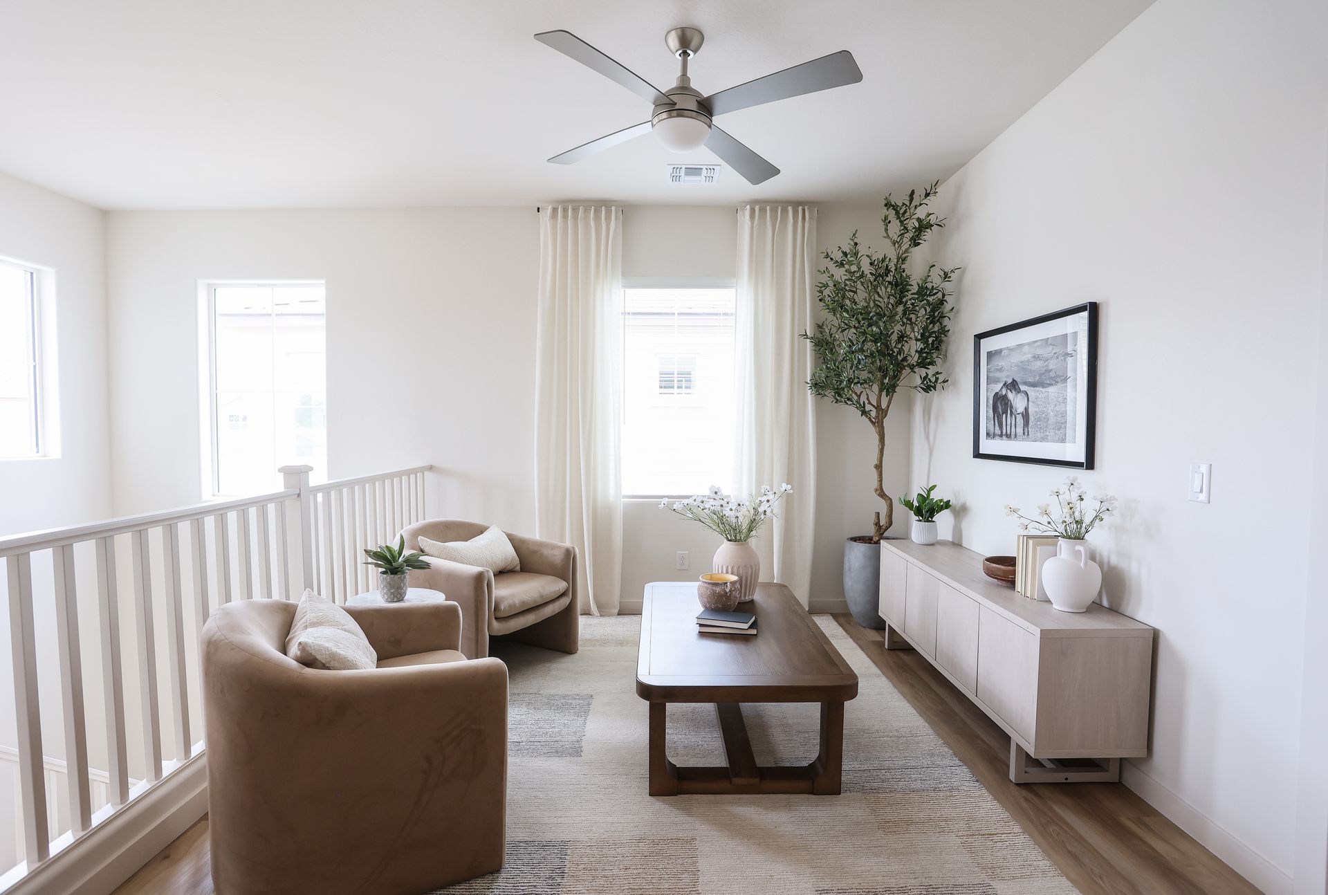 Bright living room with two armchairs, a coffee table, and a cabinet under a window.