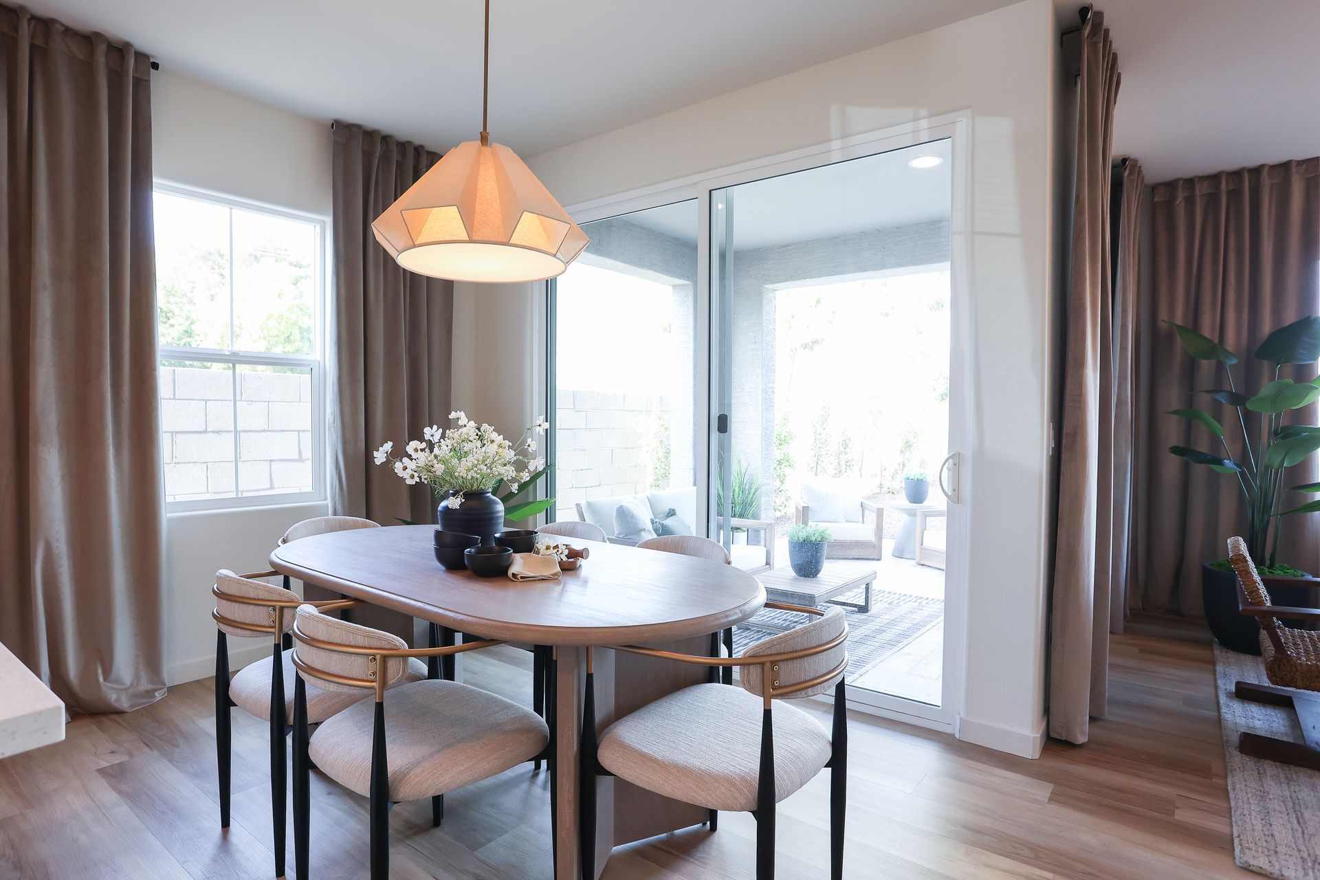 Dining area with oval table, four chairs, and sliding glass door to a patio; neutral tones.