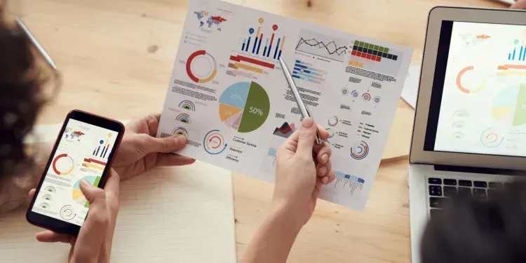 A person is holding a piece of paper with a pie chart on it.