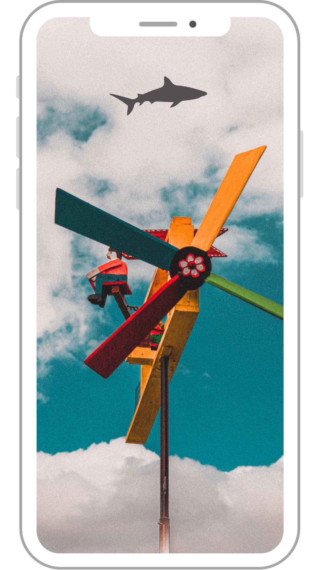 A phone with a picture of a windmill and a shark in the sky