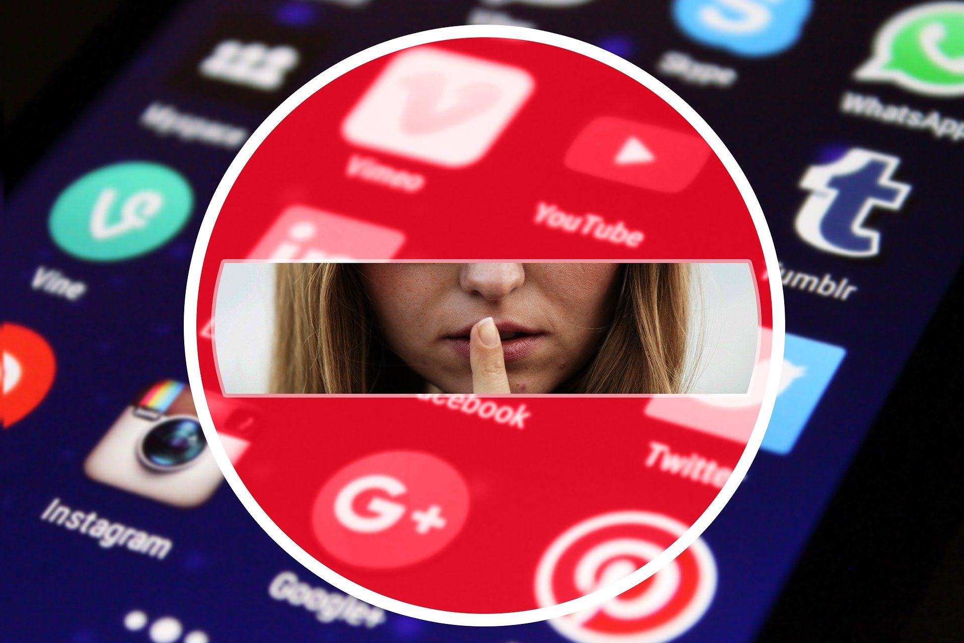 A woman holds her finger to her mouth in front of a cell phone screen