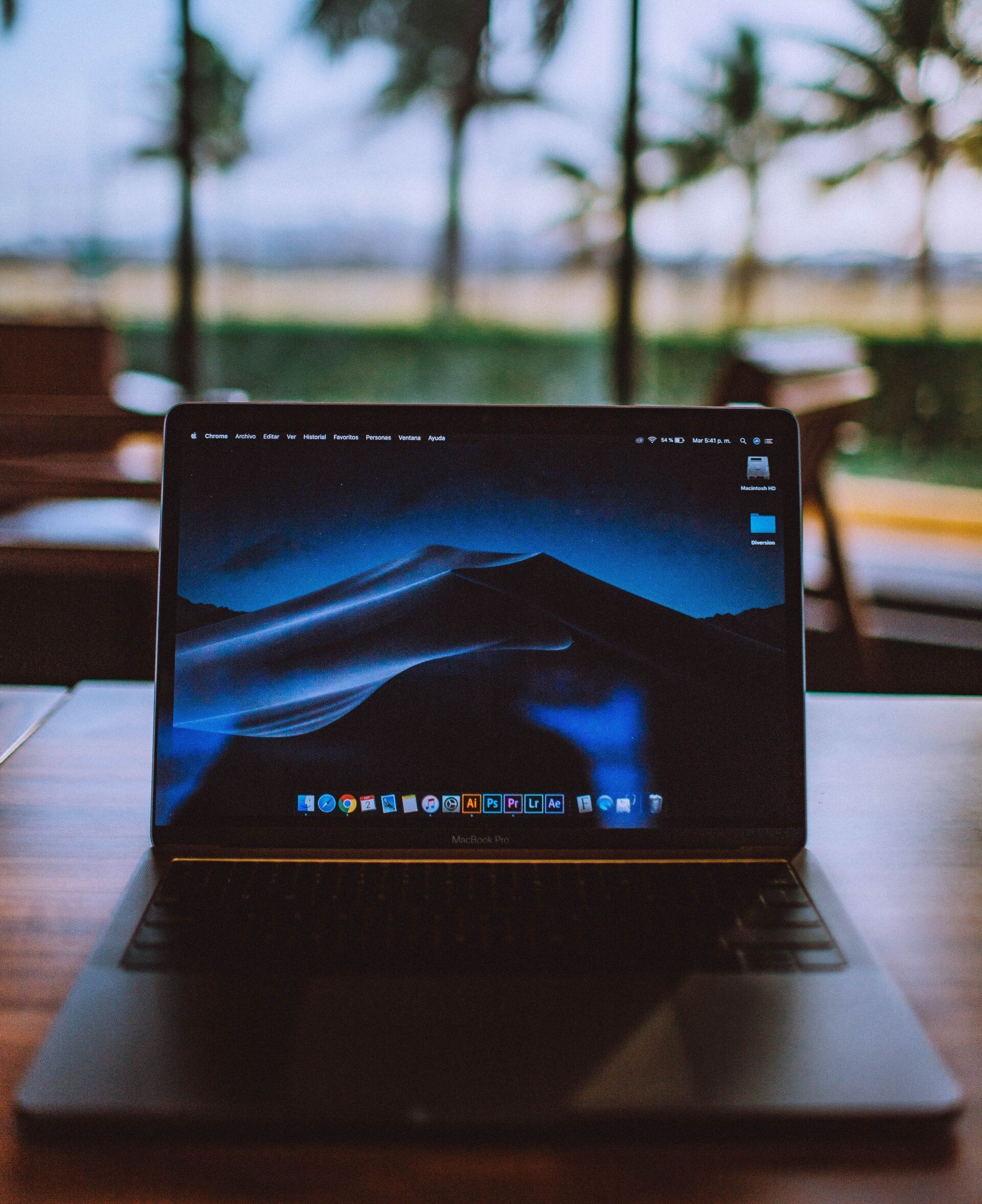 Una computadora portátil con una montaña en la pantalla está abierta sobre una mesa.