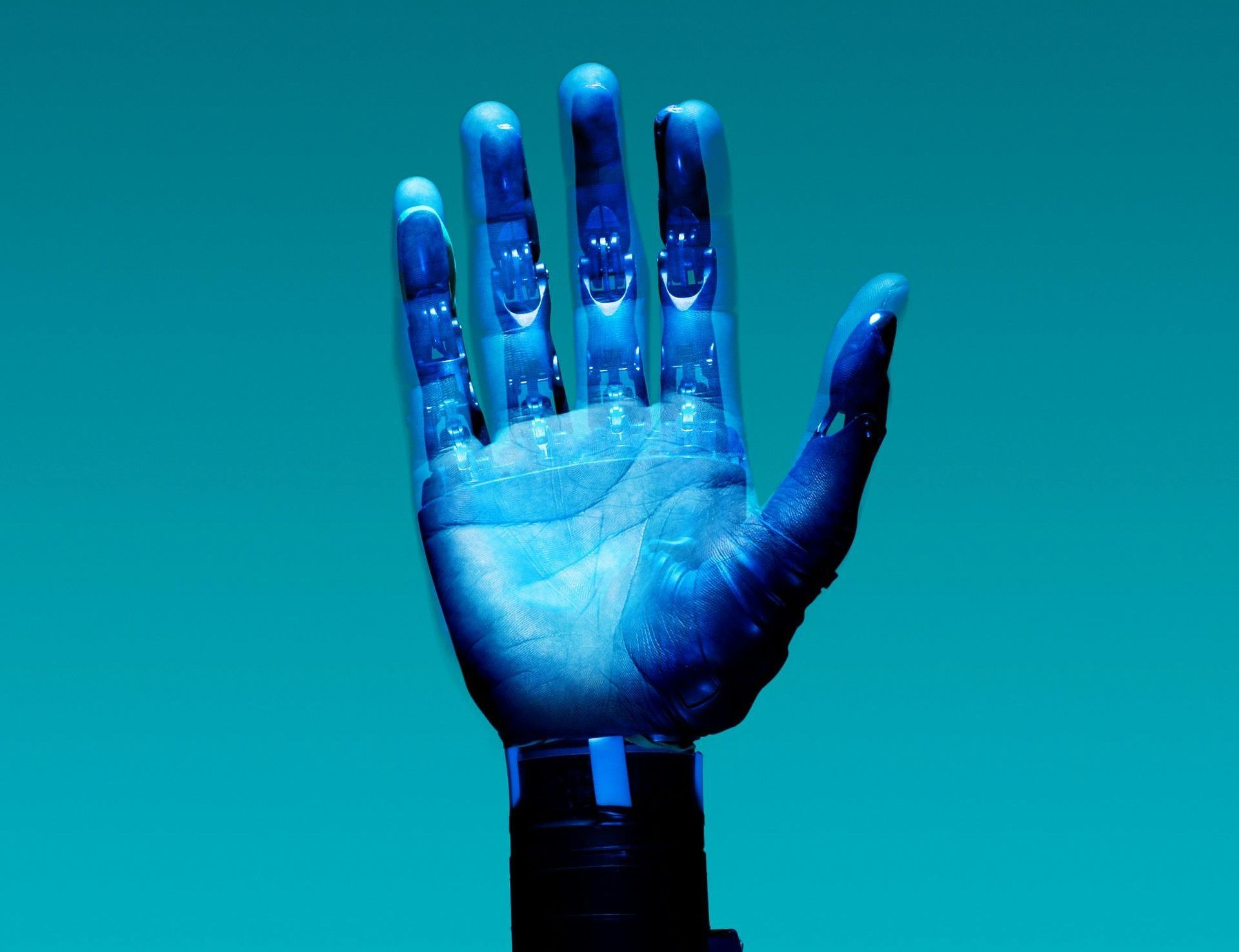 A close up of a robotic hand on a blue background.