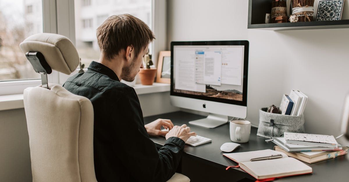 A man is sitting at a desk in front of a computer.