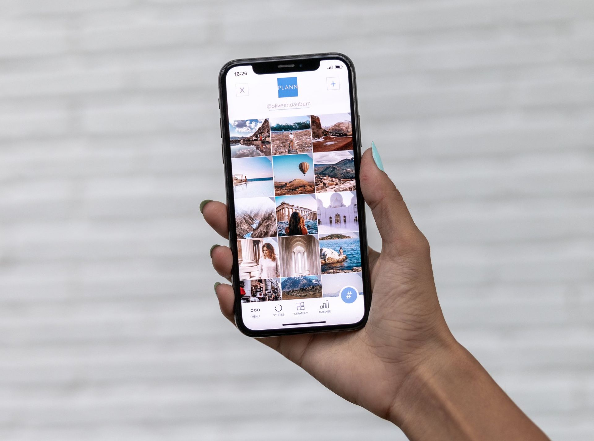 Una persona sostiene un teléfono celular con un collage de fotos en la pantalla.