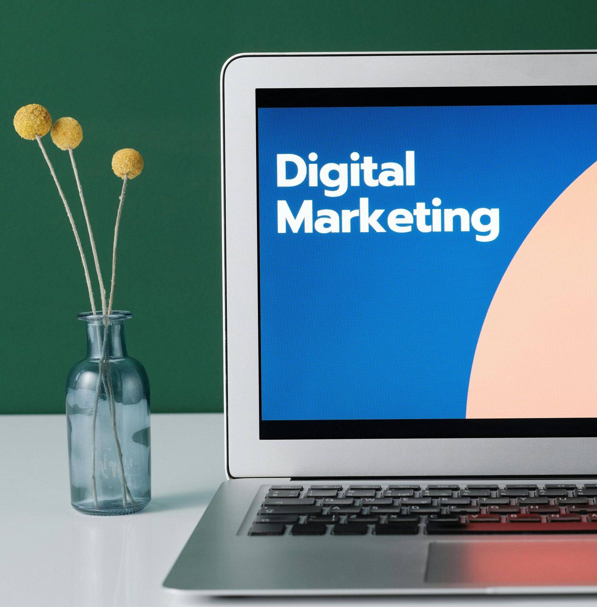 A laptop is open to a screen that says digital marketing