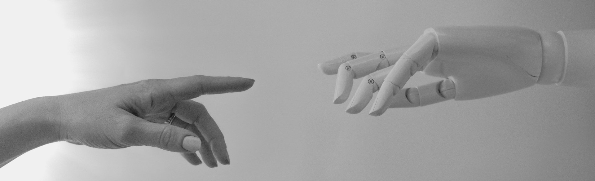 A black and white photo of two hands reaching for each other.