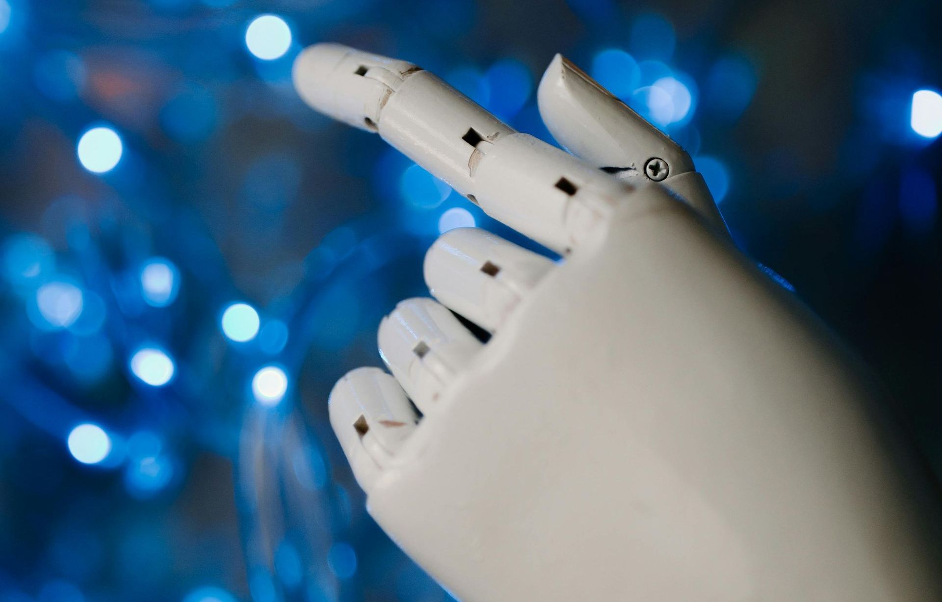 A close up of a robotic hand pressing a button.