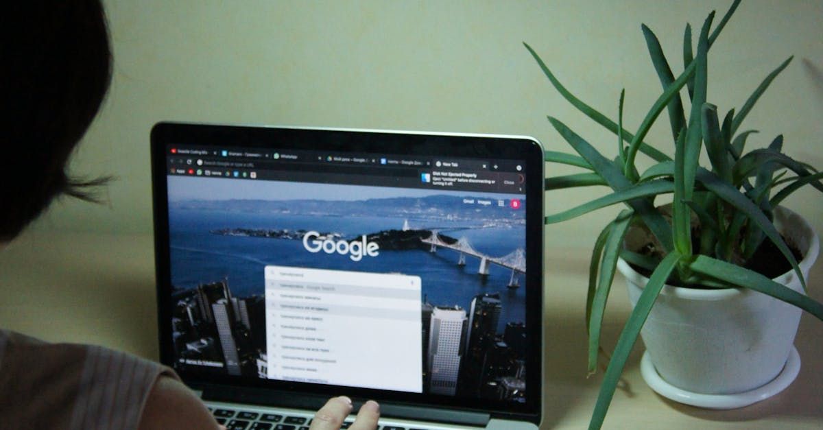 A woman is using a laptop computer with the google website open.