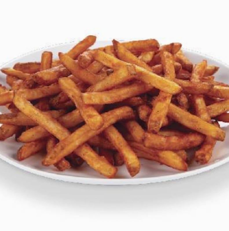 A white plate topped with french fries on a white background