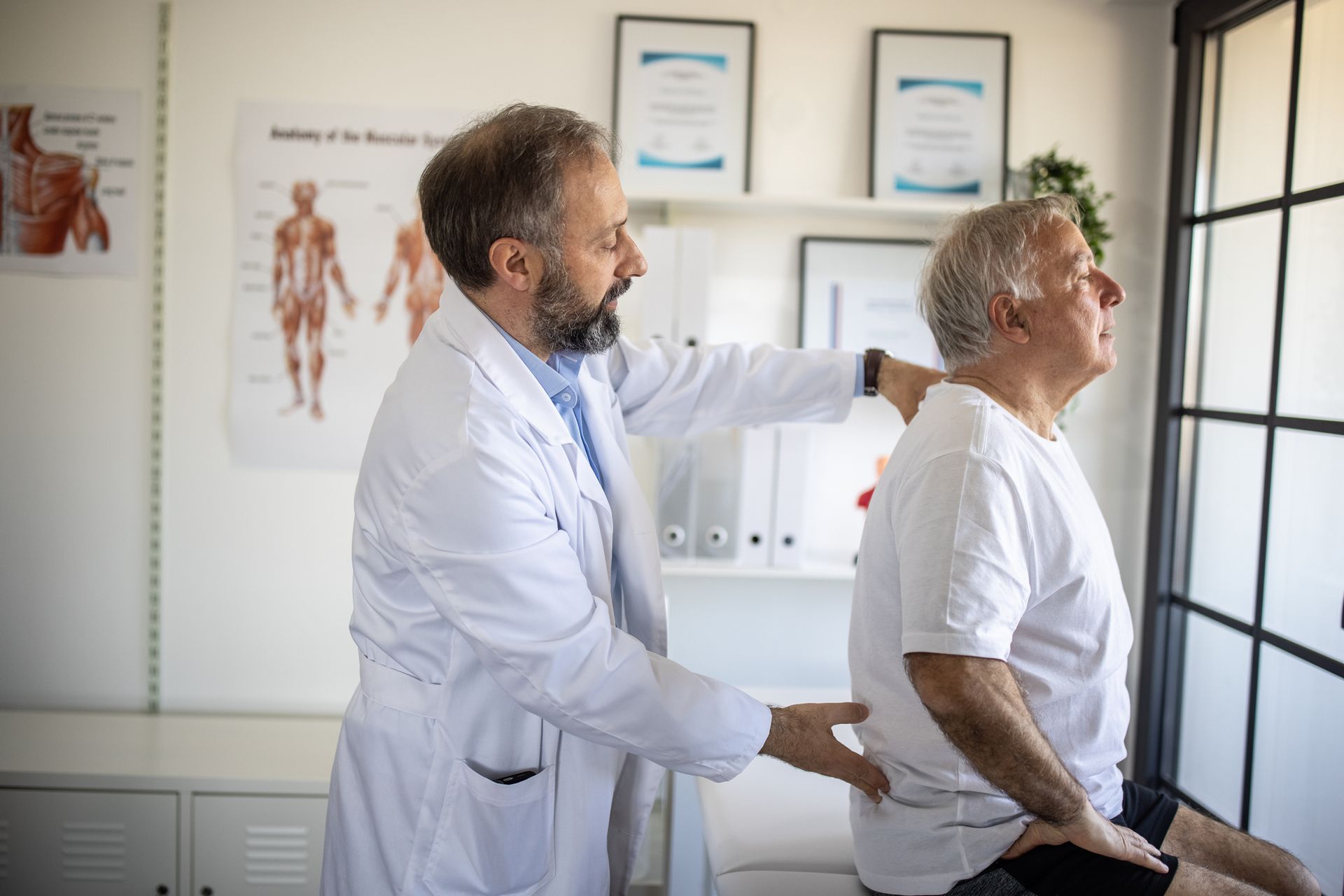 Patient getting back adjustment from physician at injury doctor office during recovery session.