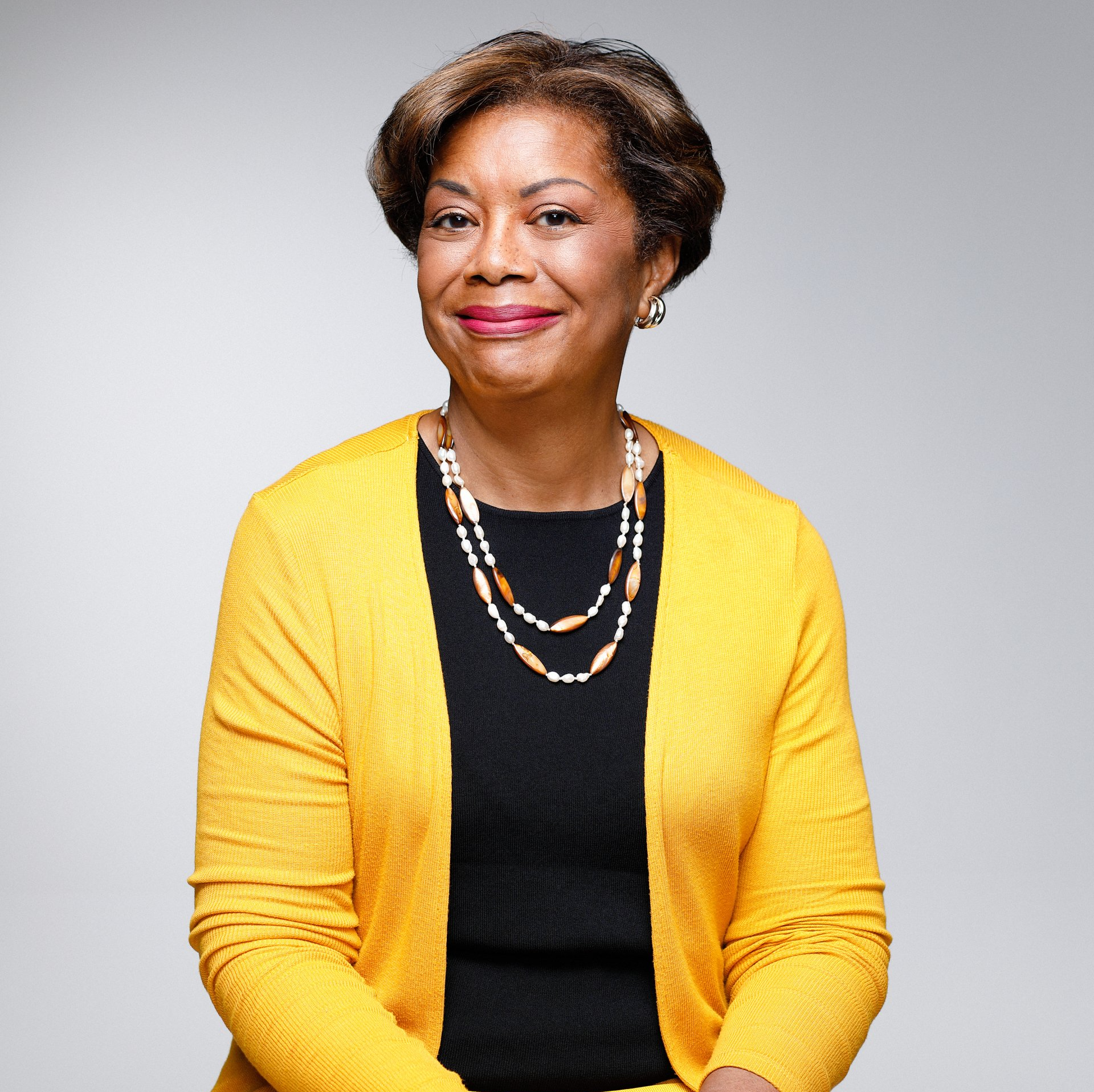 A woman wearing a yellow cardigan and a black shirt