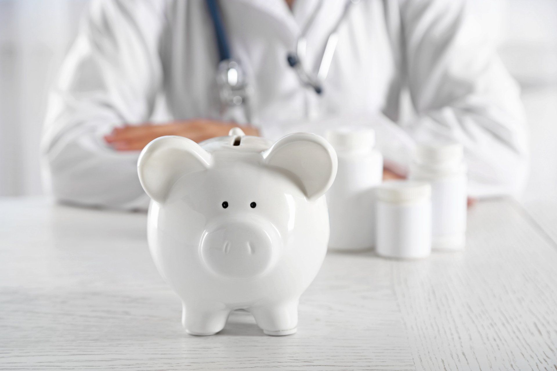 White piggy bank in front of a doctor, suggesting healthcare savings.