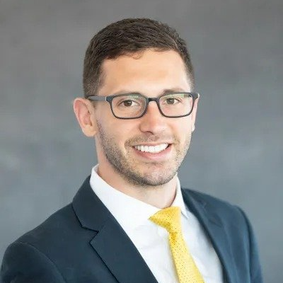 A man in a suit and tie is smiling for the camera.