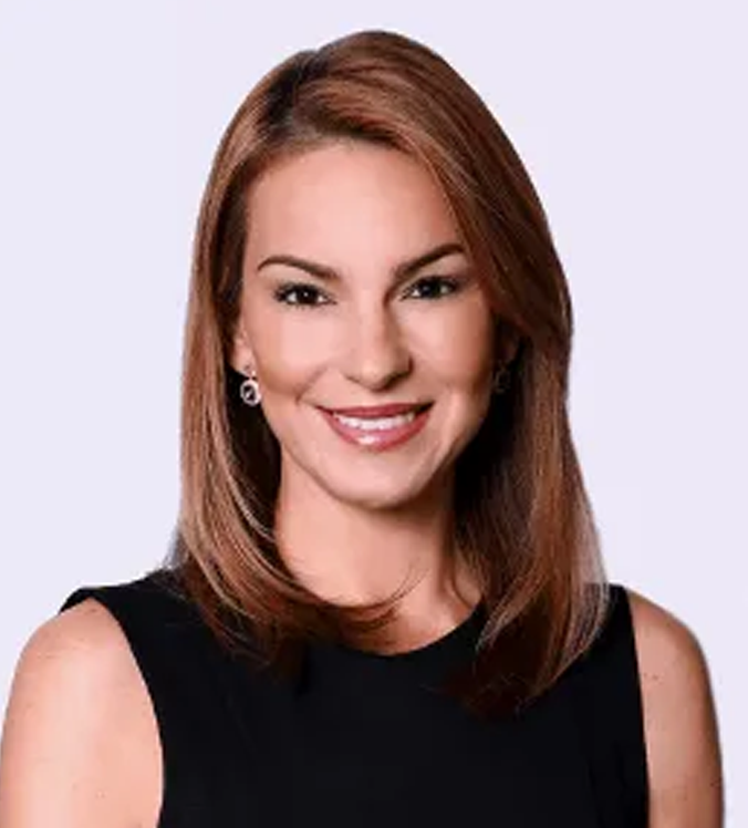 Woman with brown hair smiling, wearing a black sleeveless top, against a white background.