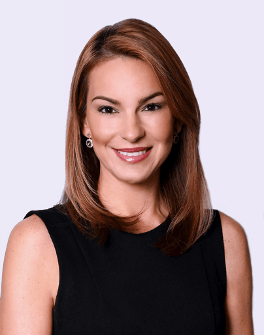 A woman in a black dress is smiling for the camera