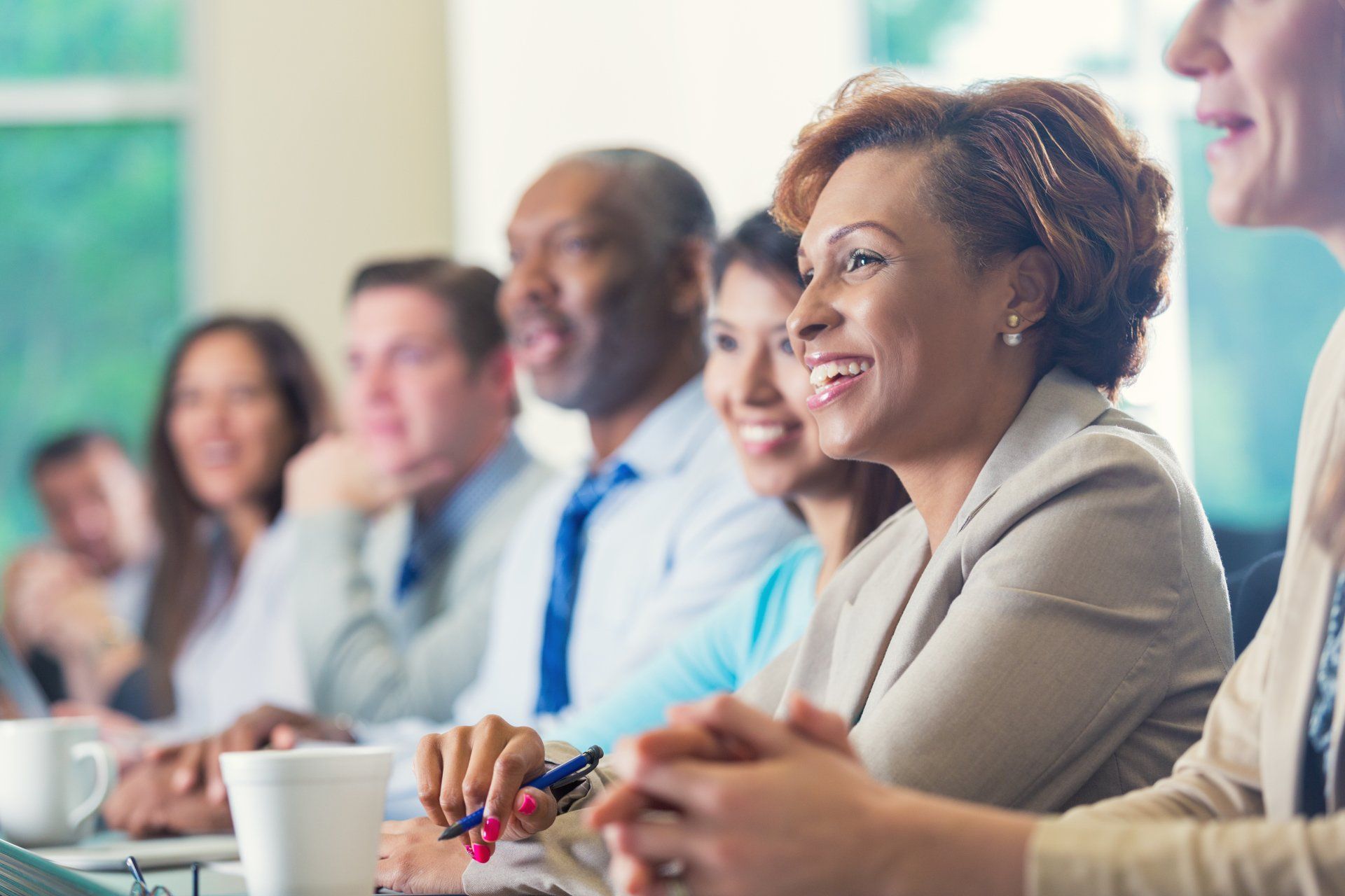 A group of people are sitting at a table in a conference room.