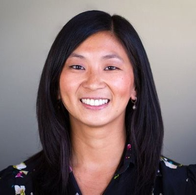 A woman with long black hair is smiling for the camera.