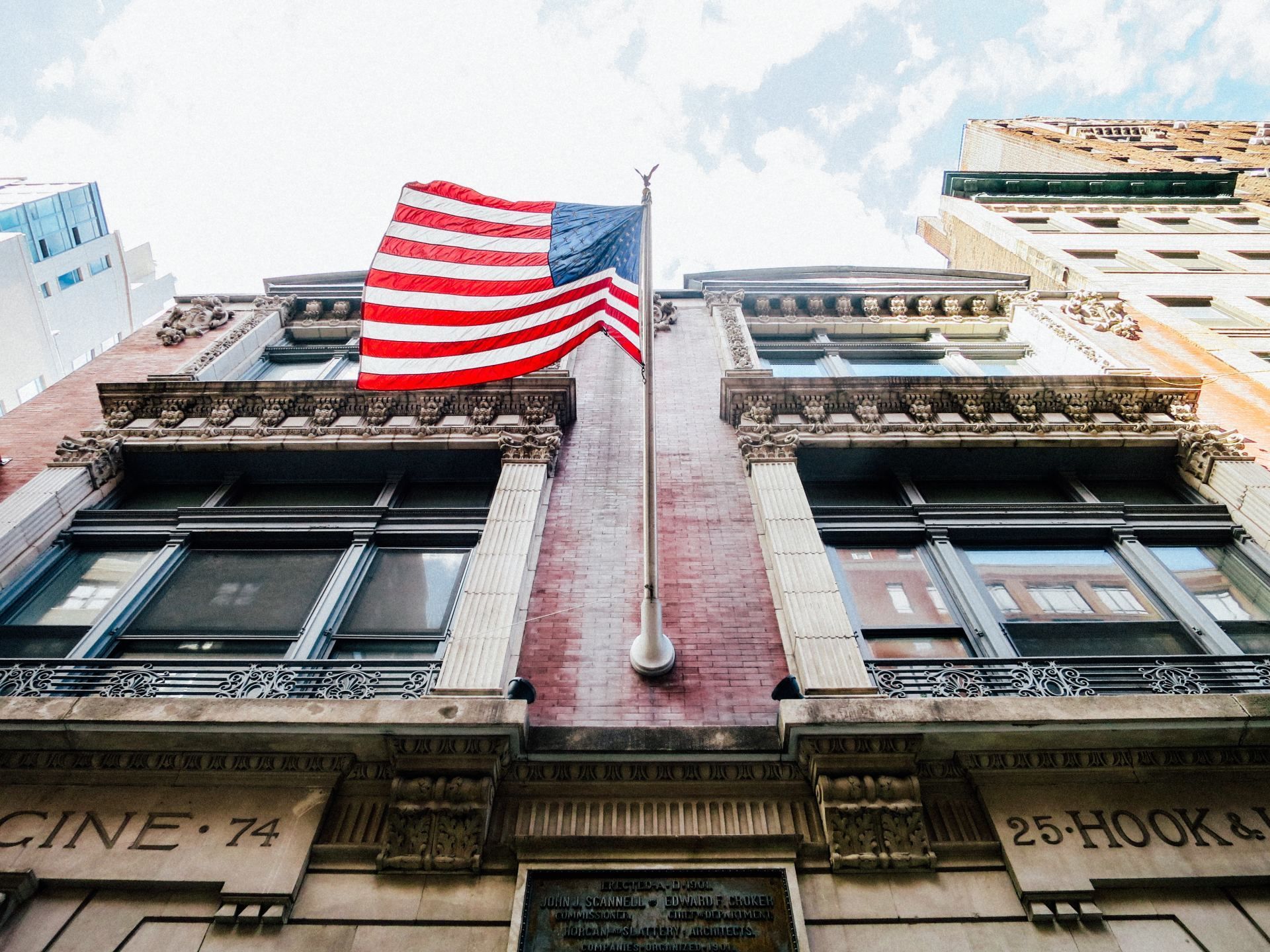 American flag flying high on a brick building in New York City.