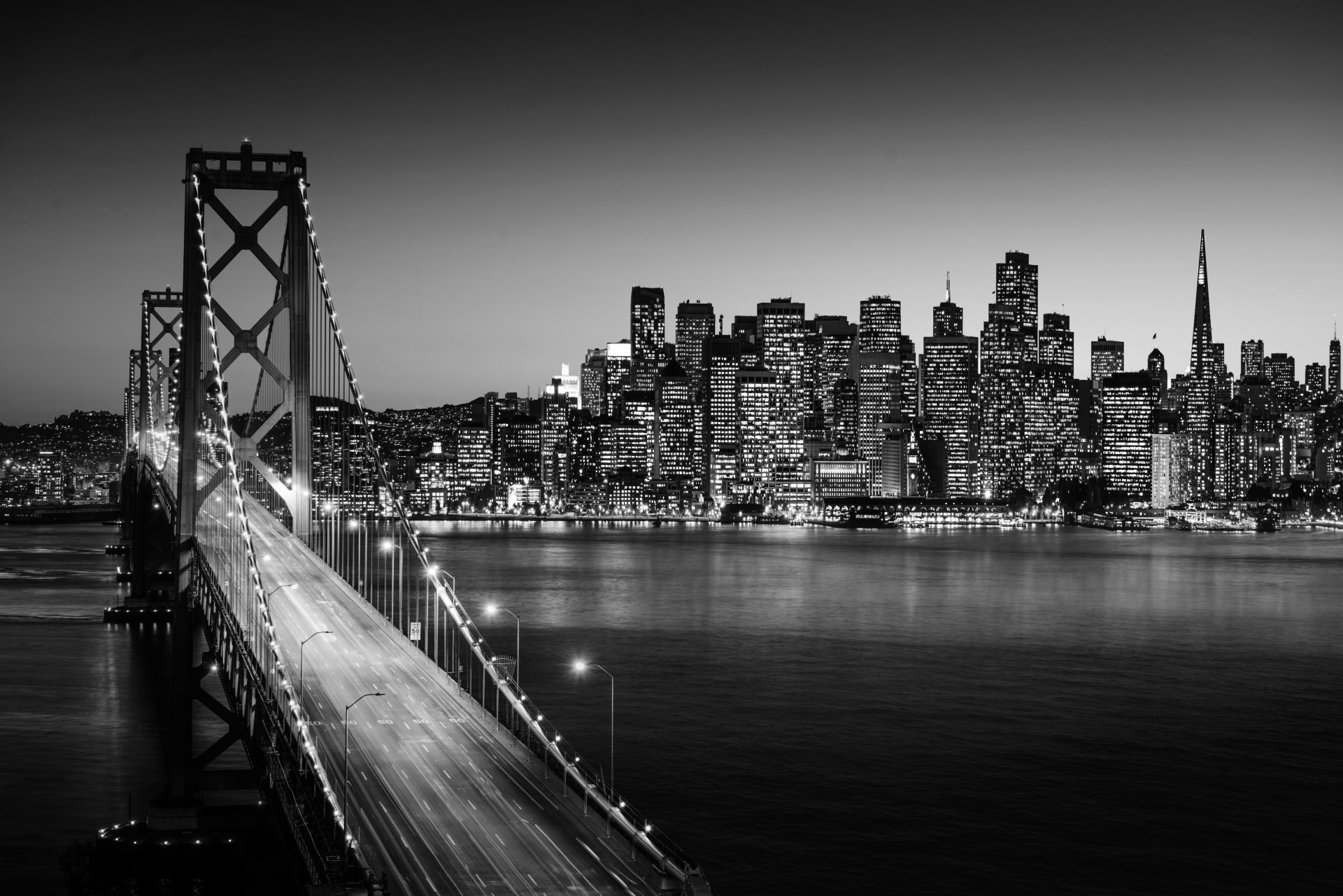 A black and white photo of a bridge over a body of water