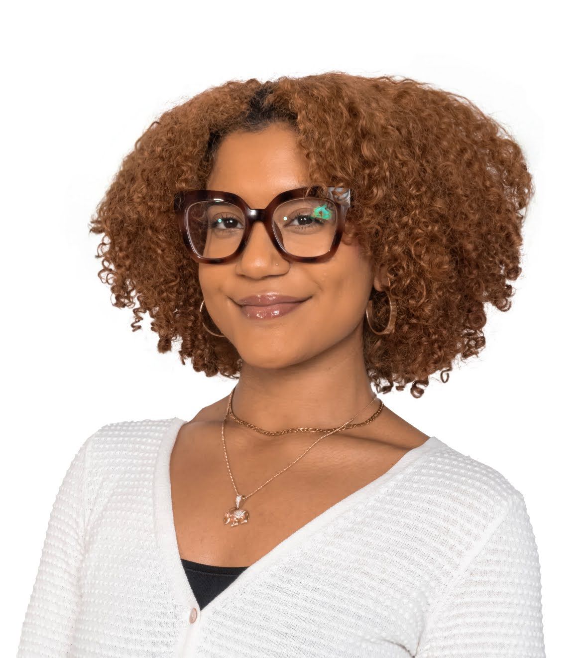 Woman with curly auburn hair, glasses, and a white sweater smiles.