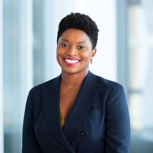 A woman in a blue shirt is smiling for the camera.