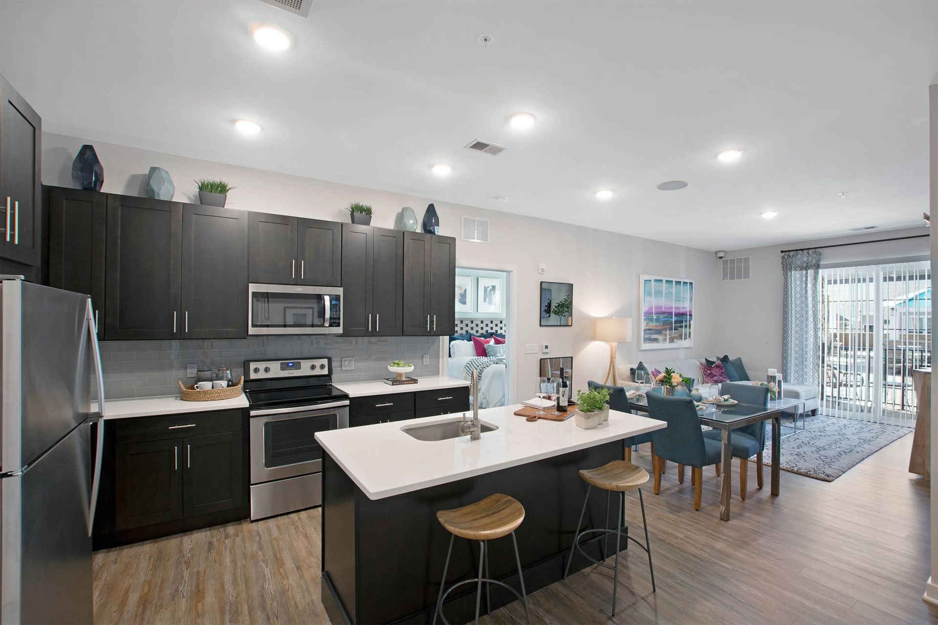 Open-concept kitchen with island, dark cabinets, and stainless steel appliances beside the living area at The Parc at Roxbury in  Roxbury, NJ.