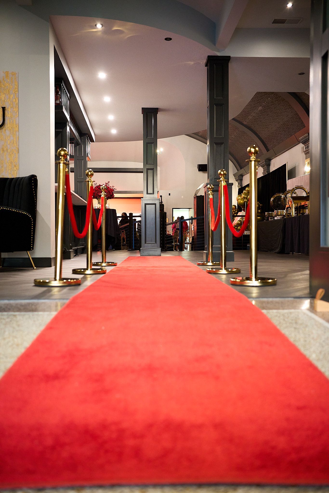 A long red carpet is lined up in a hallway.