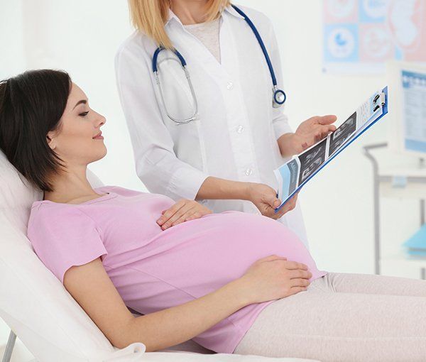 Ginecologa con ecografie e donna incinta