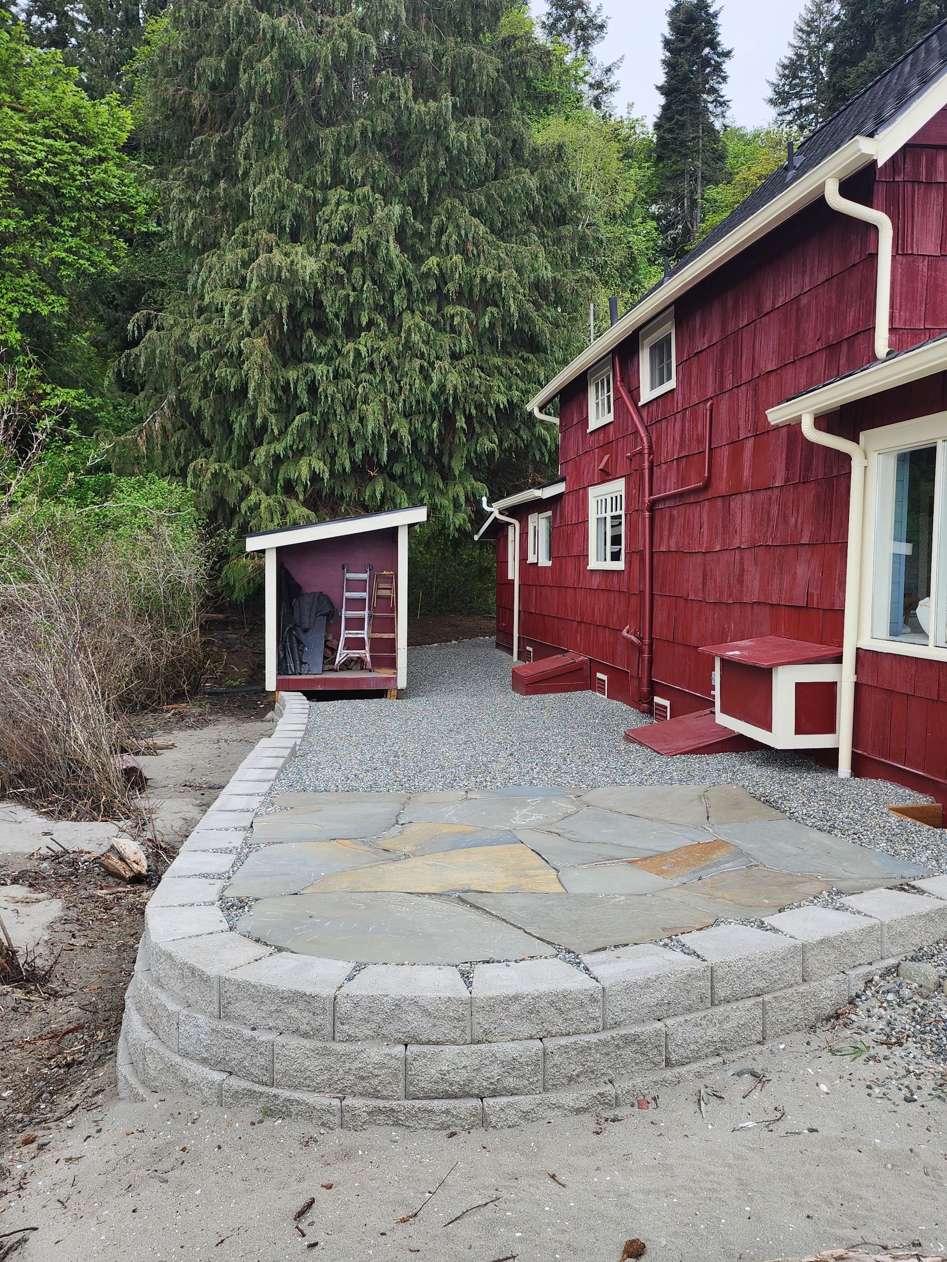 A red house with a dog kennel in front of it.