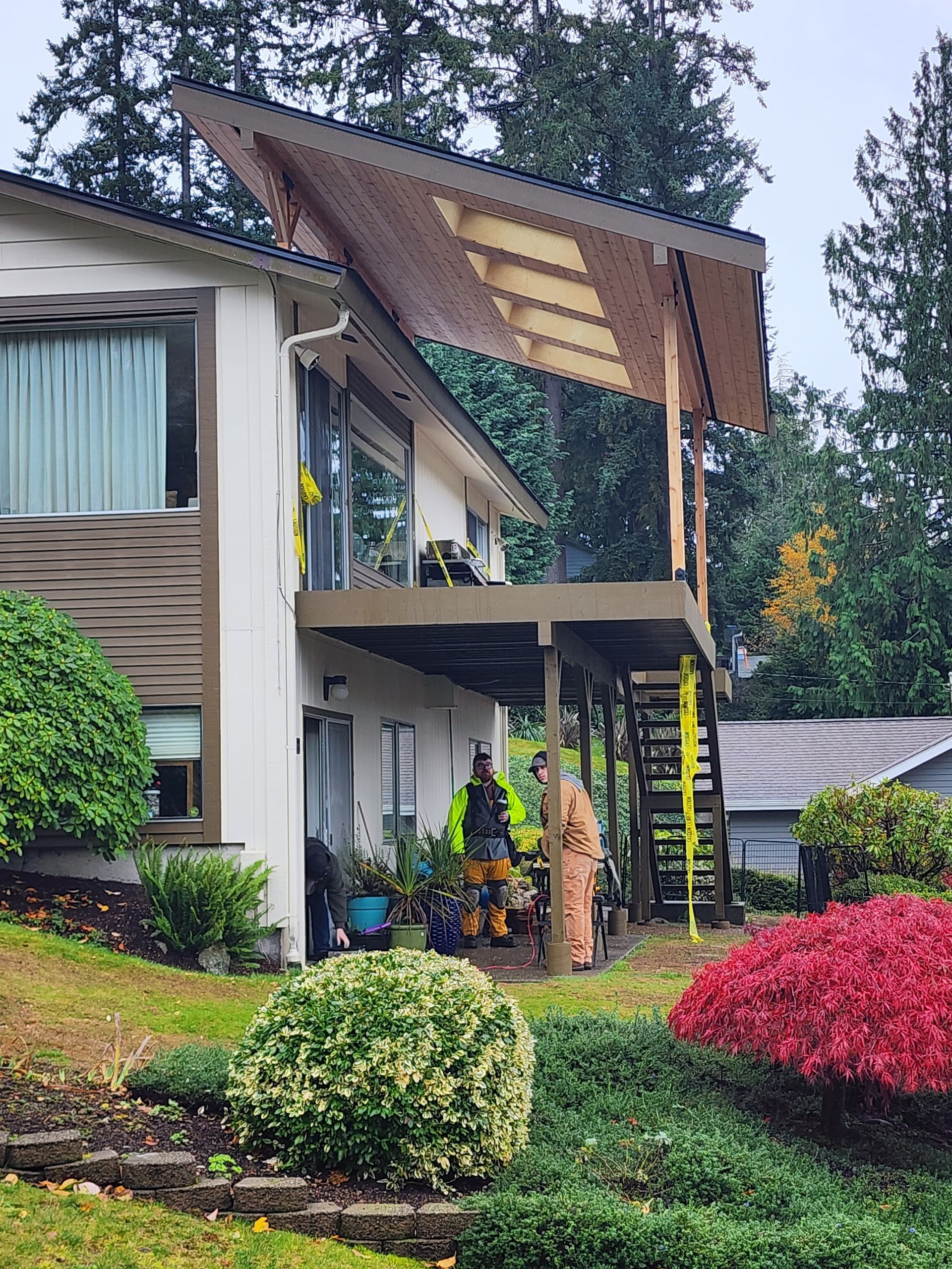 A fireman is standing in front of a house with a deck.