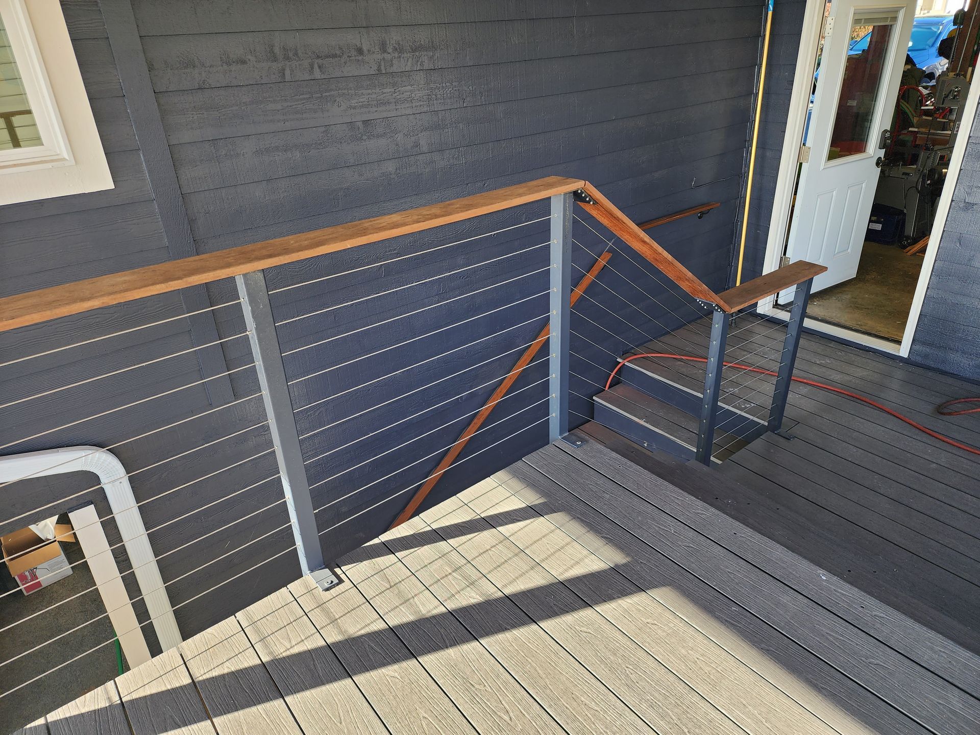 A staircase leading up to a deck with a wooden railing.
