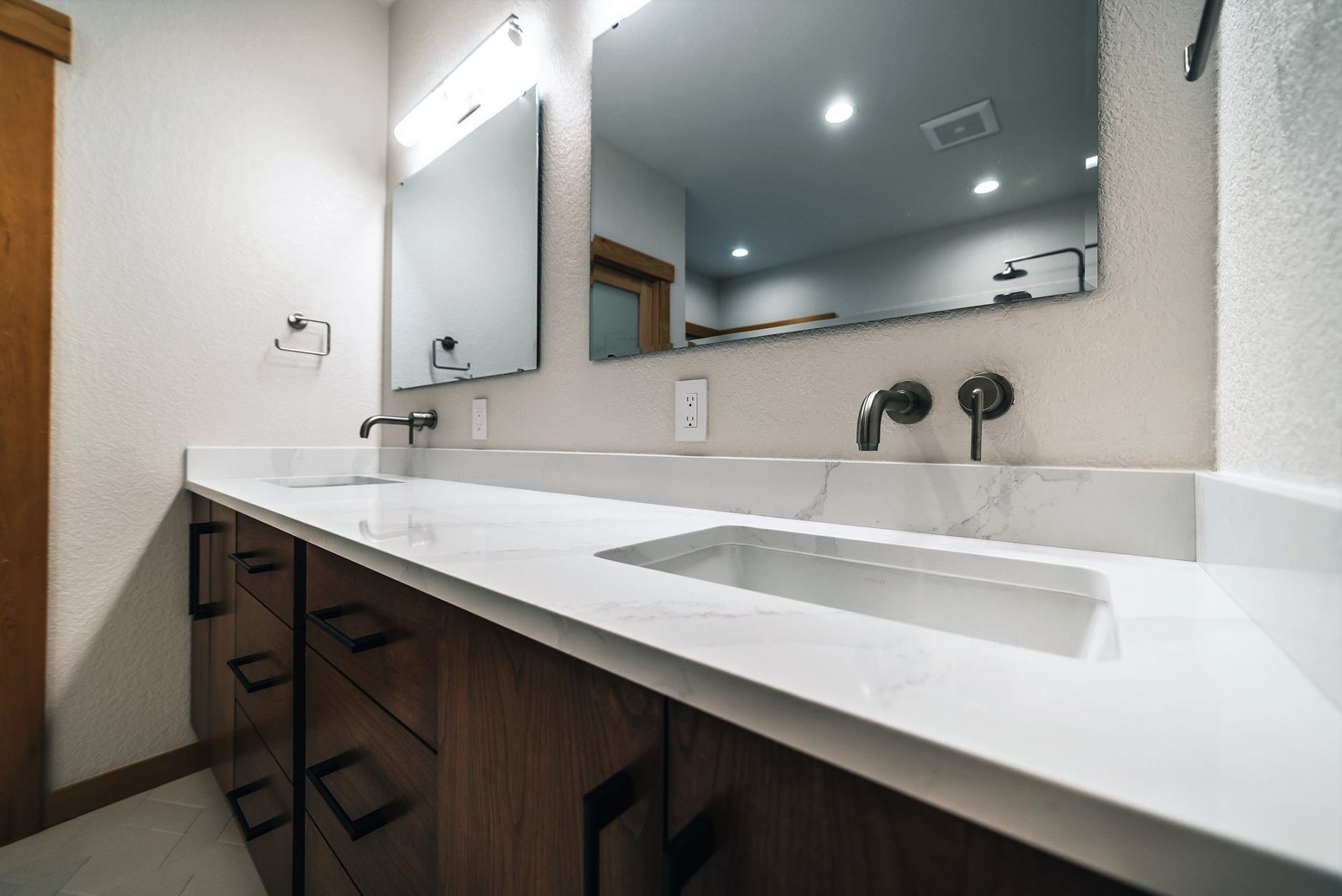 A bathroom with two sinks and a large mirror.