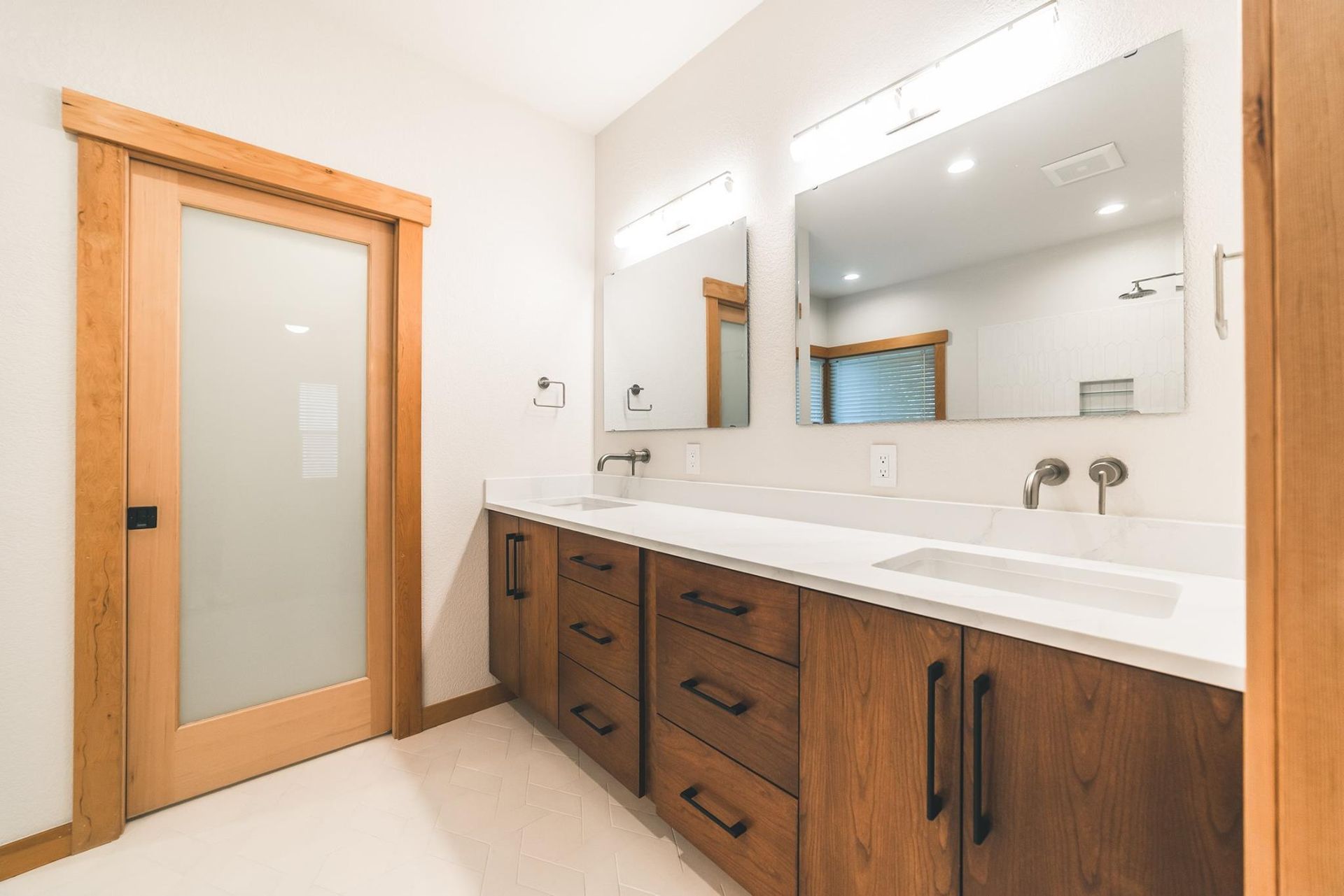 A bathroom with two sinks and a large mirror.