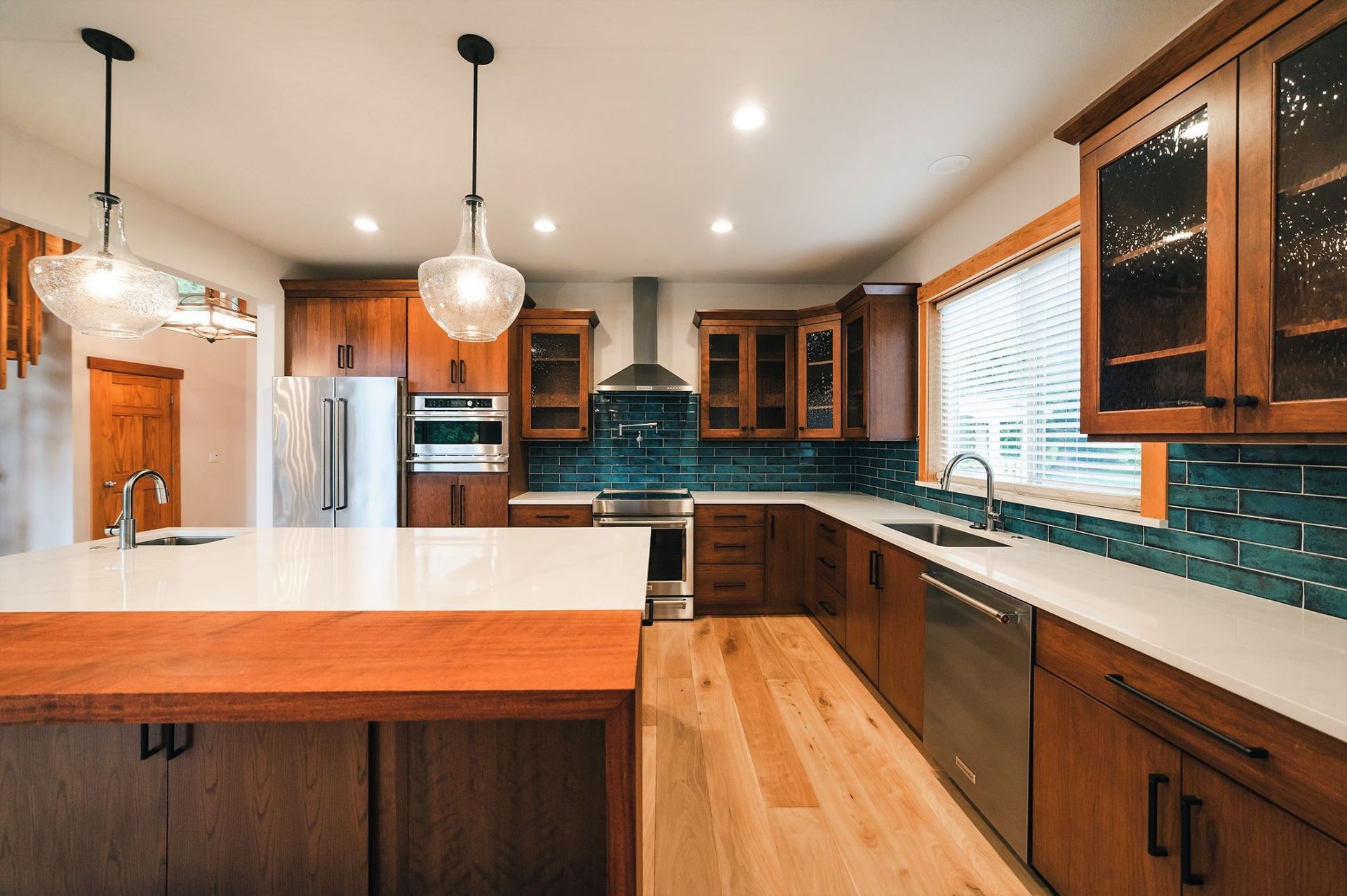 A kitchen with wooden cabinets, stainless steel appliances, and a large island.