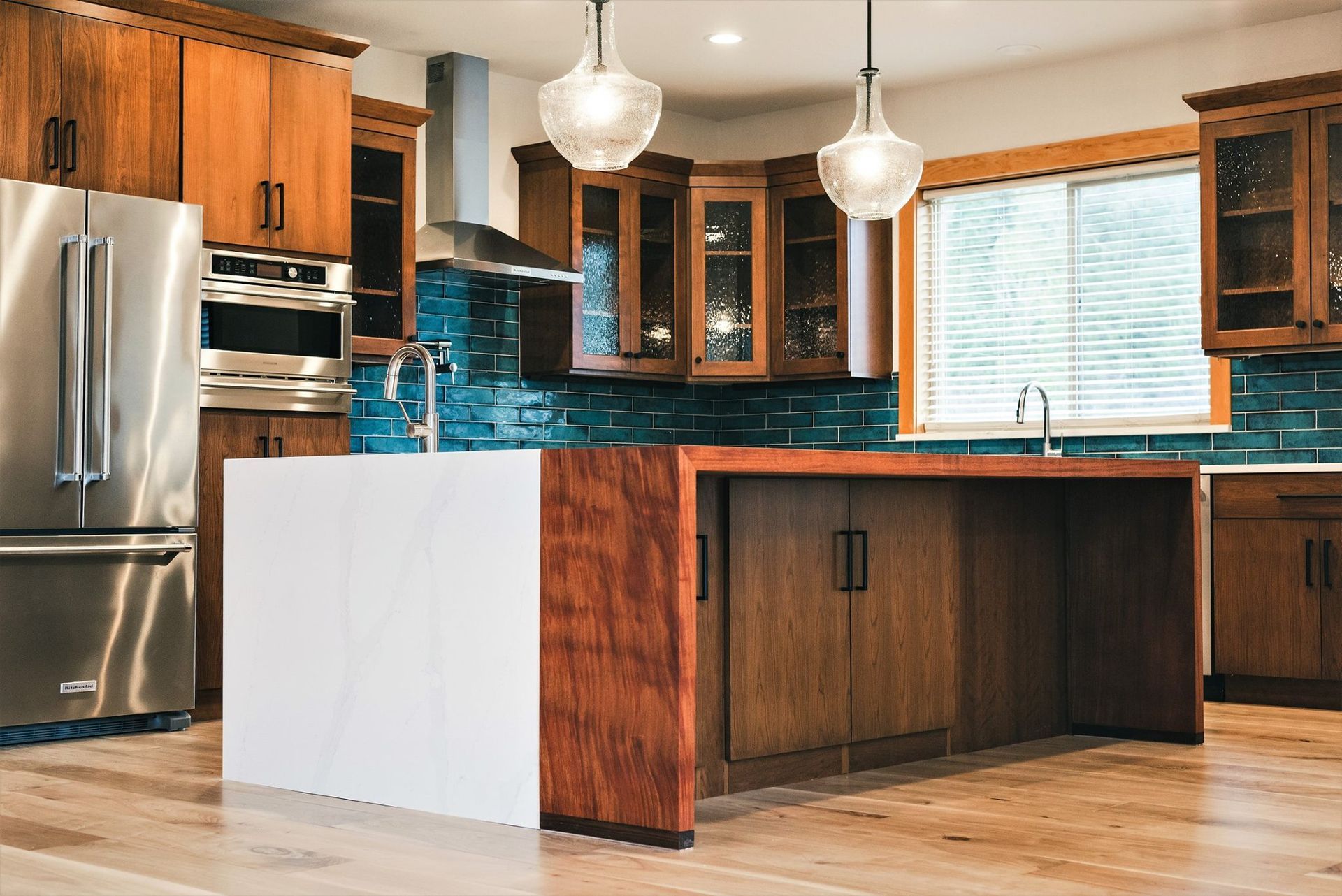 A kitchen with wooden cabinets, stainless steel appliances, and a large island.