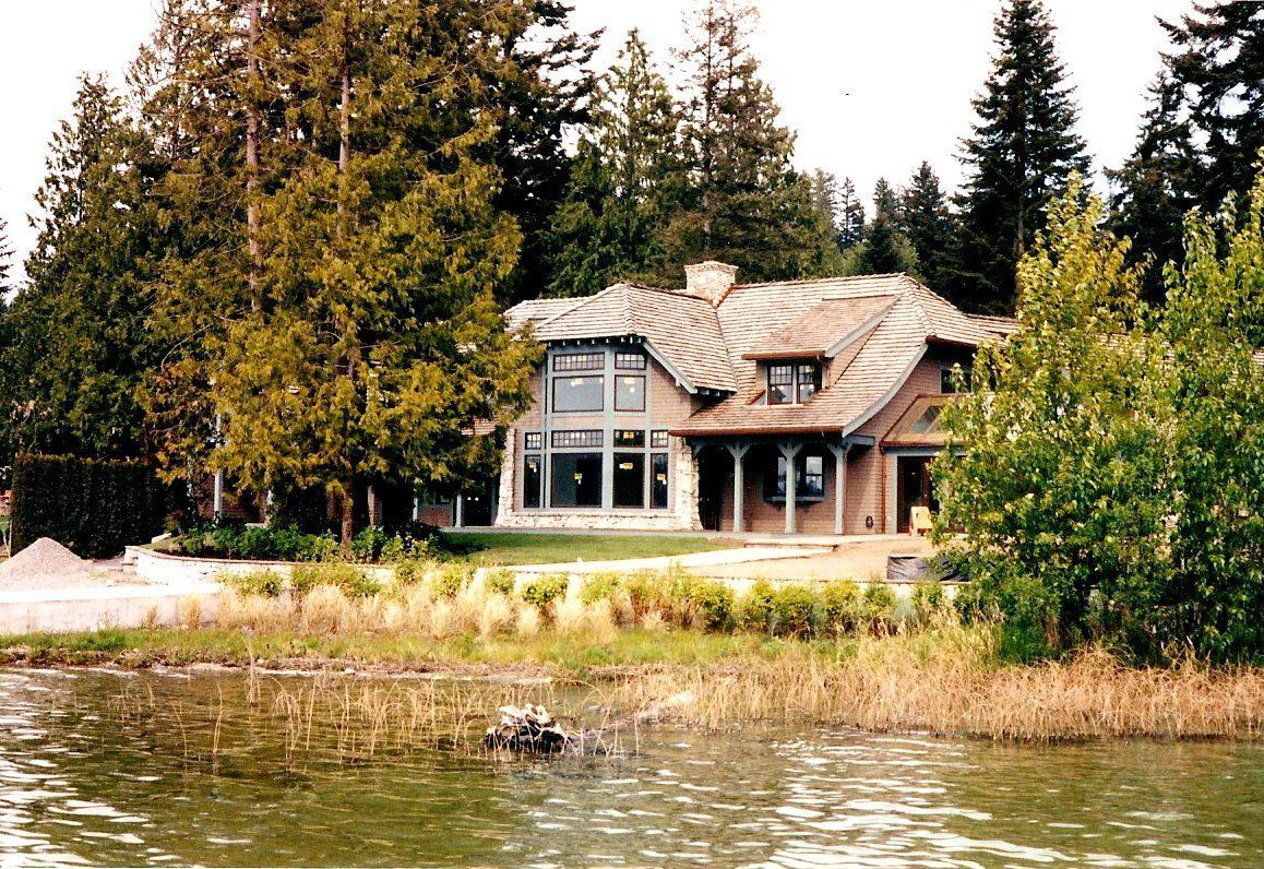 A large house sits on the shore of a lake.