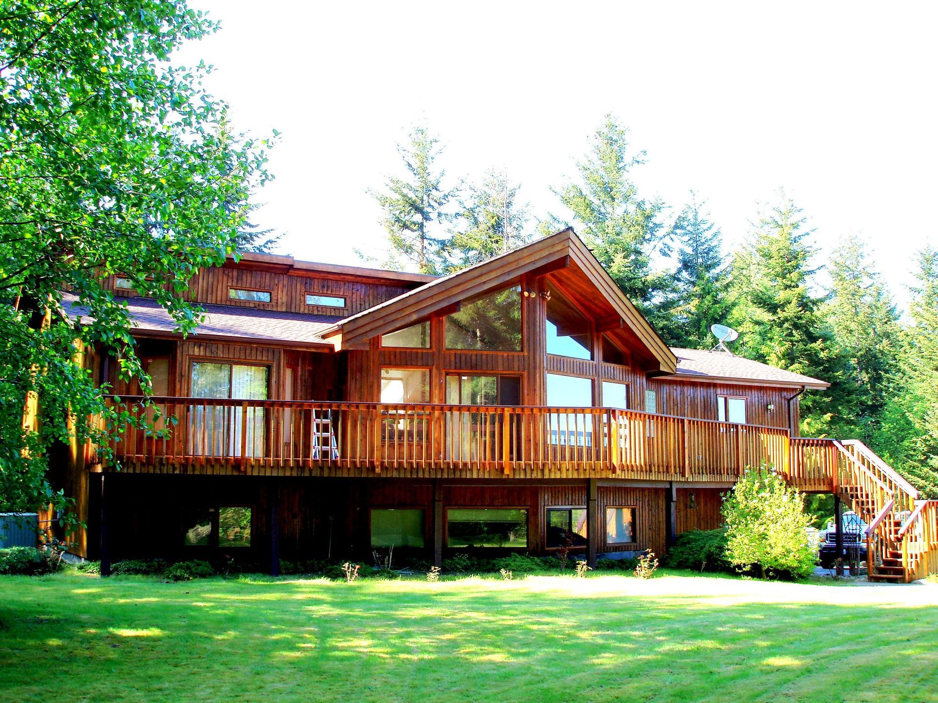 A large wooden house with a large deck and stairs.