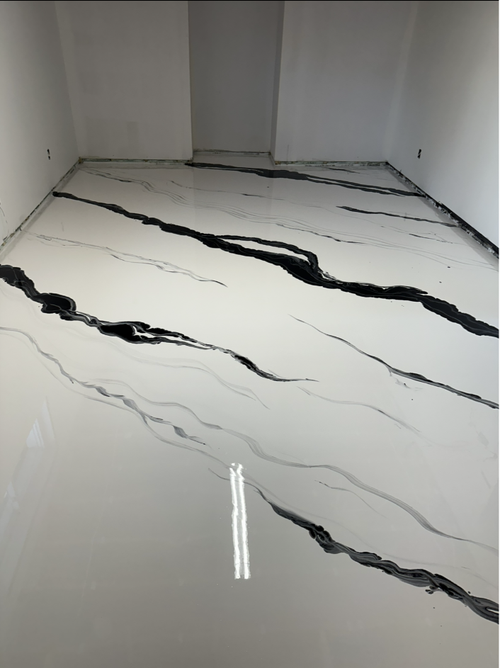 Une pièce avec un sol en marbre noir et blanc et une fenêtre.