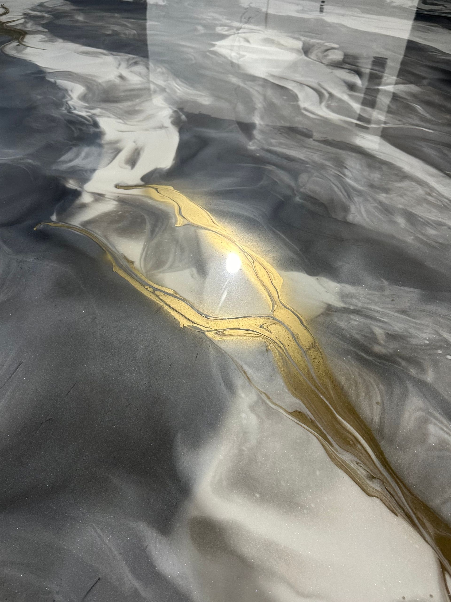 Un gros plan d'un sol en marbre noir et blanc avec une bande dorée.