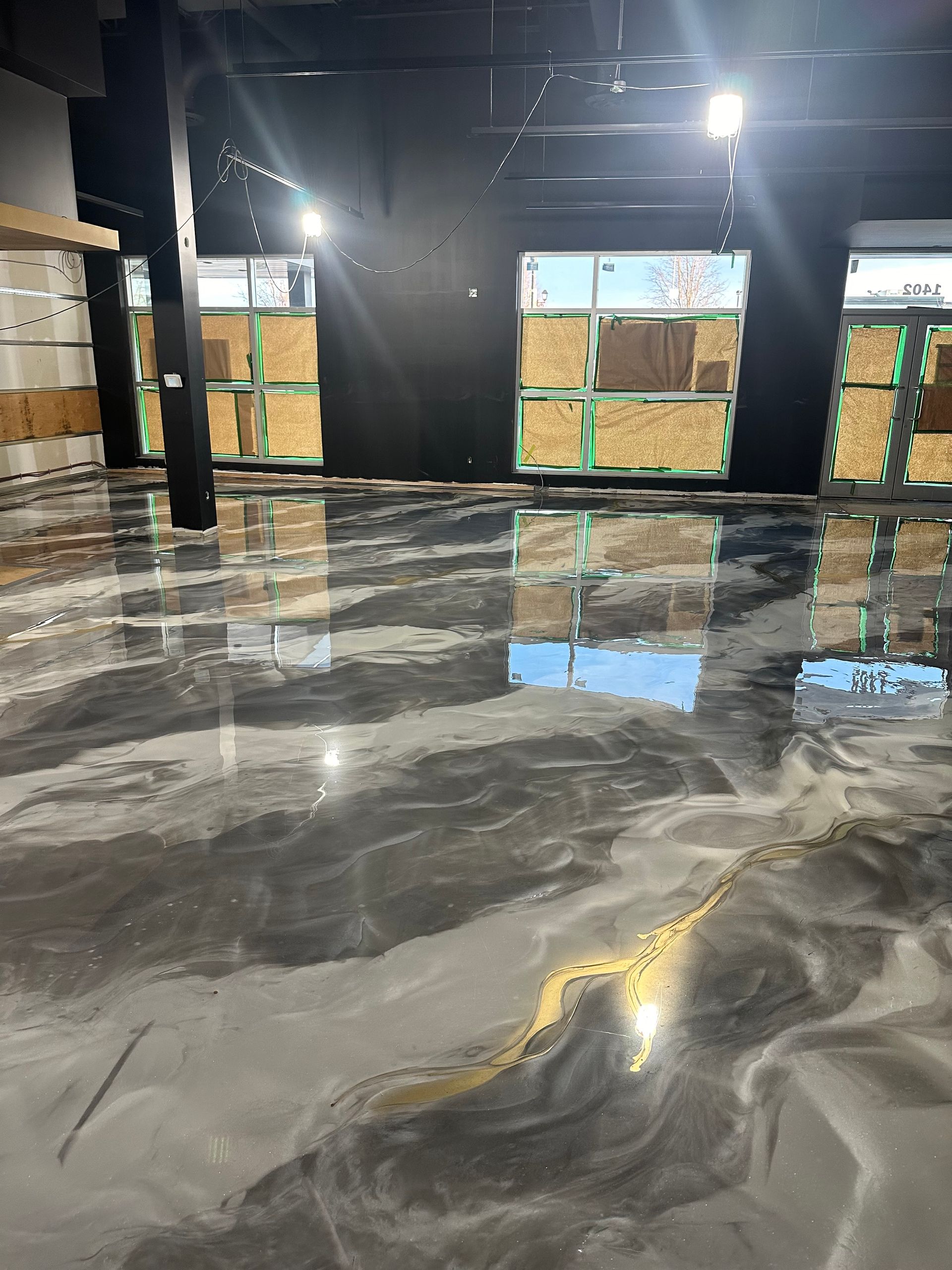 Une pièce avec un sol brillant et un mur noir.