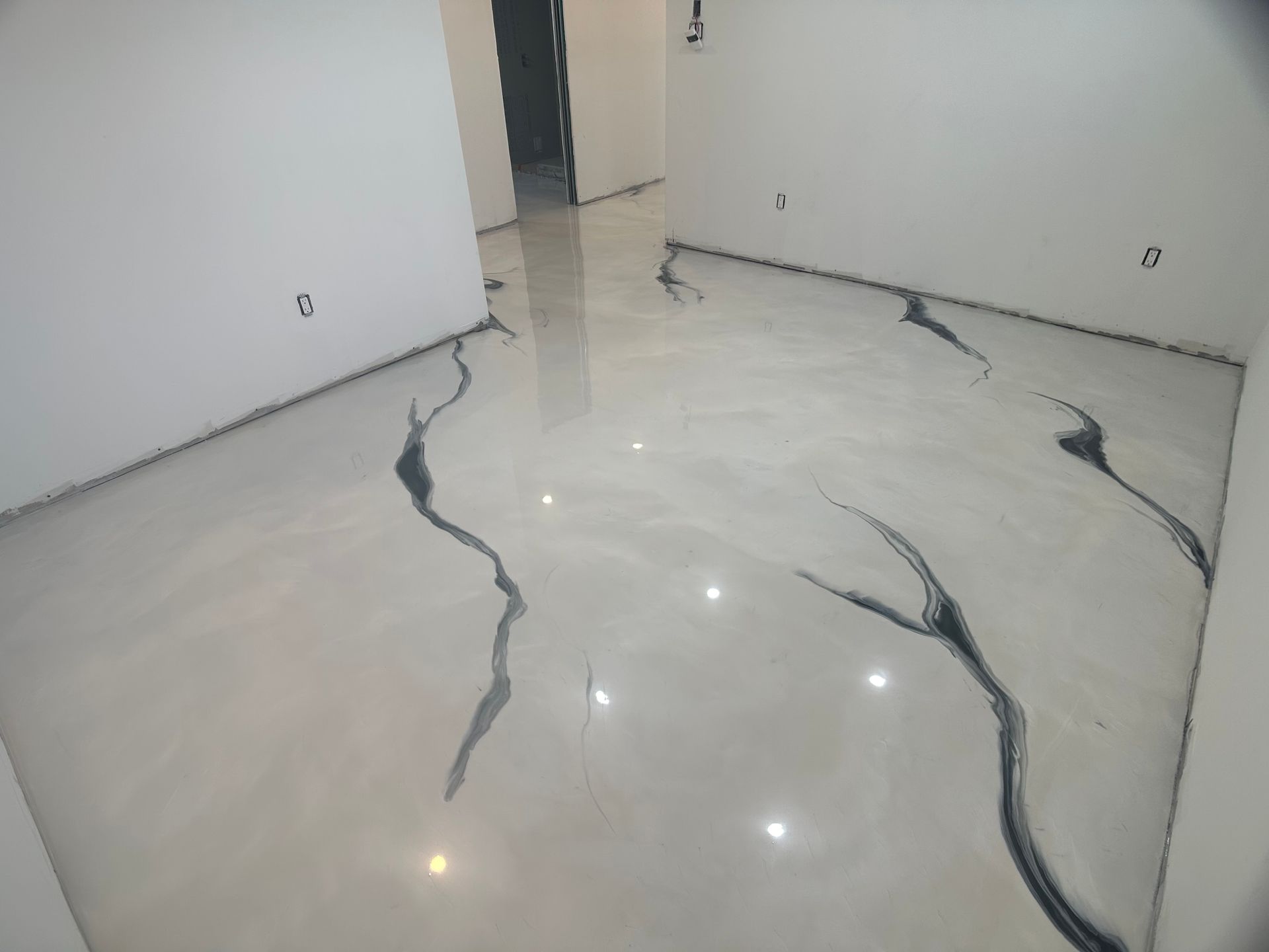 Une pièce avec un sol blanc et des fissures noires.