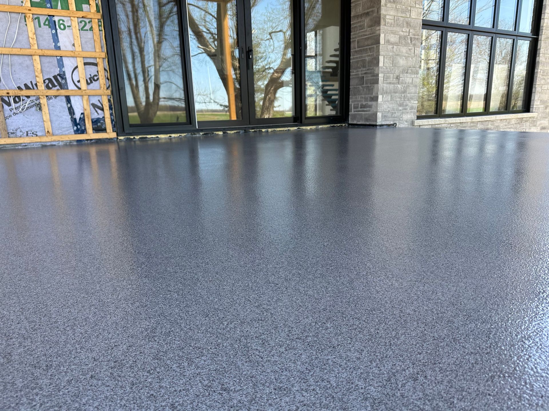 Un sol en béton devant un bâtiment avec des portes coulissantes en verre.