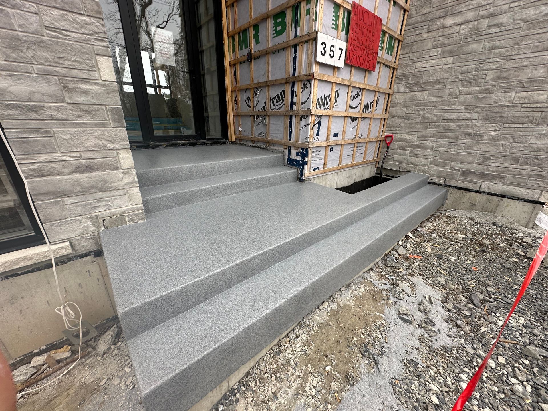 Une personne se tient devant un bâtiment avec des escaliers.