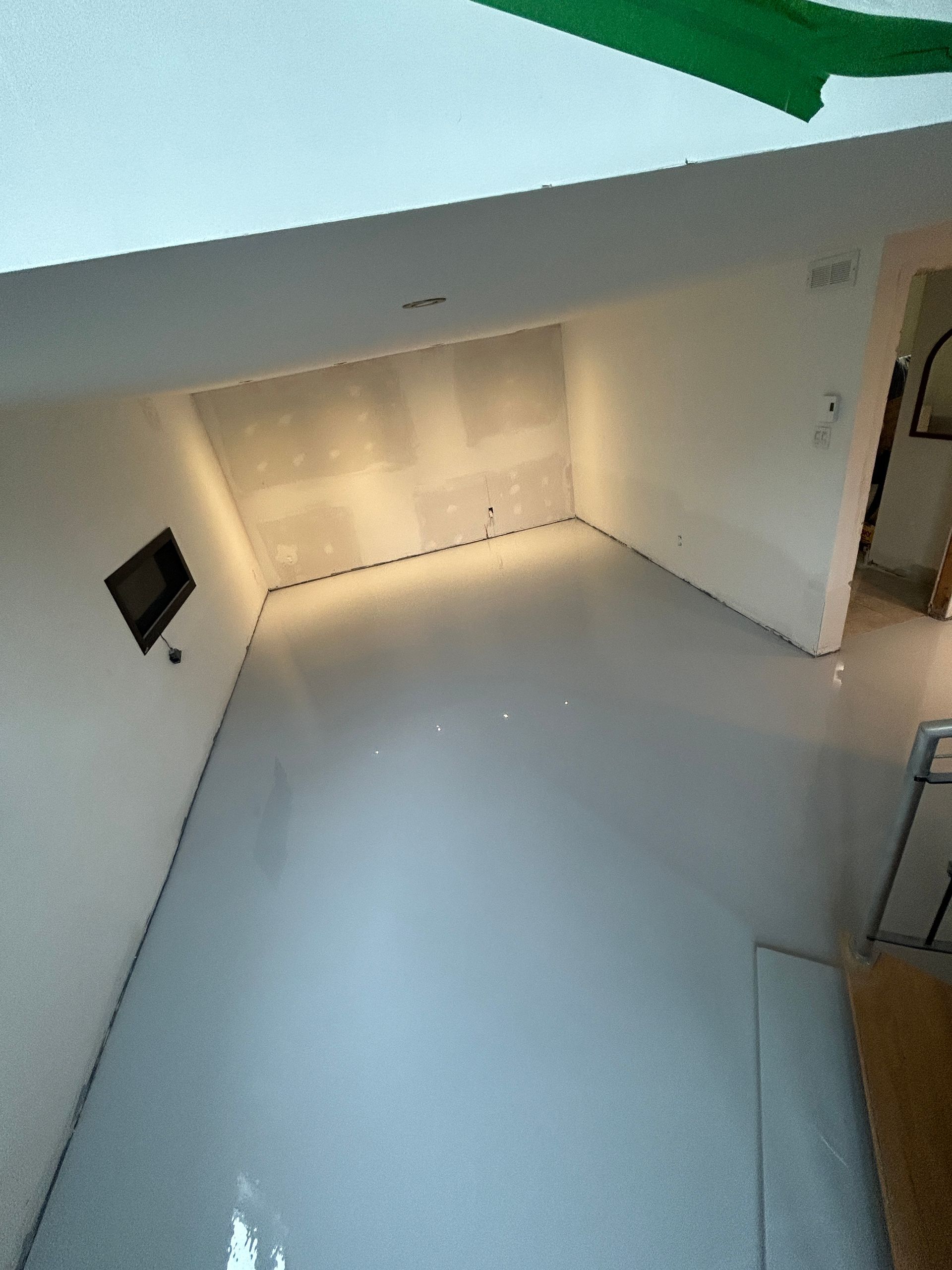 Une vue aérienne d'une pièce avec un sol blanc et des murs blancs.