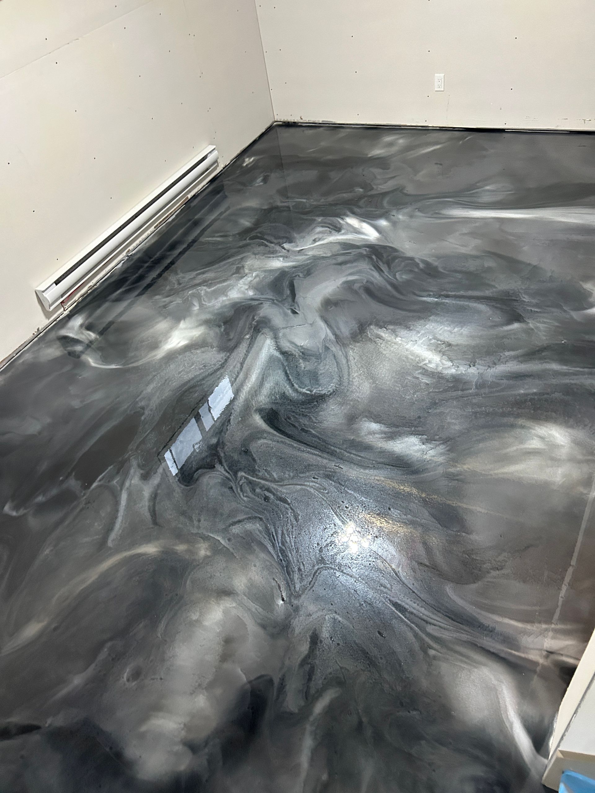 Un sol époxy noir et blanc dans une pièce.