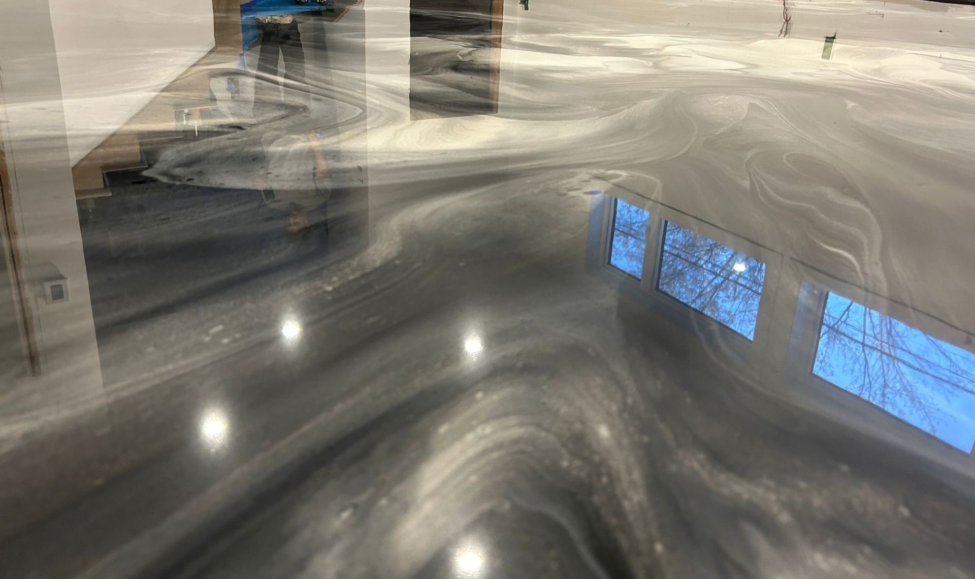 Un sol métallique brillant avec le reflet d'une fenêtre à l'intérieur.