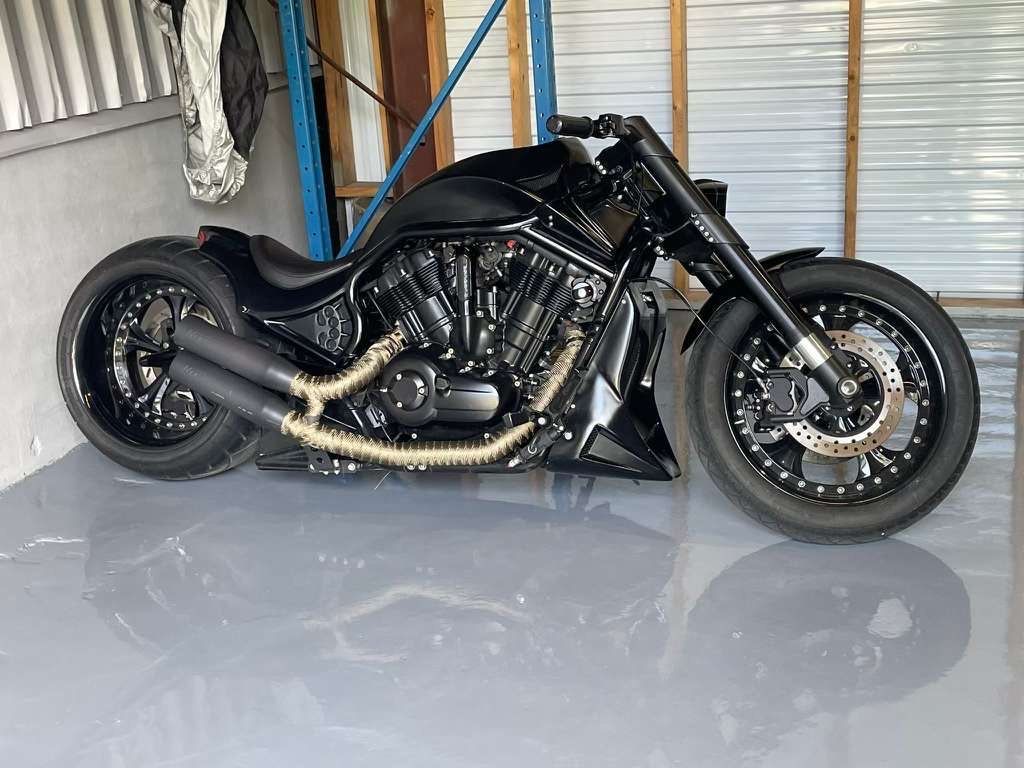 Une moto noire est garée dans un garage.