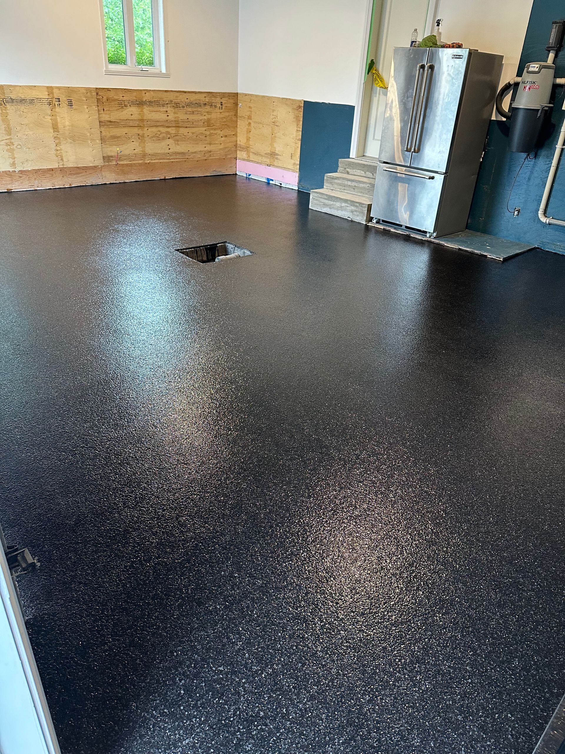 Un garage vide avec des armoires blanches et une porte de garage ouverte