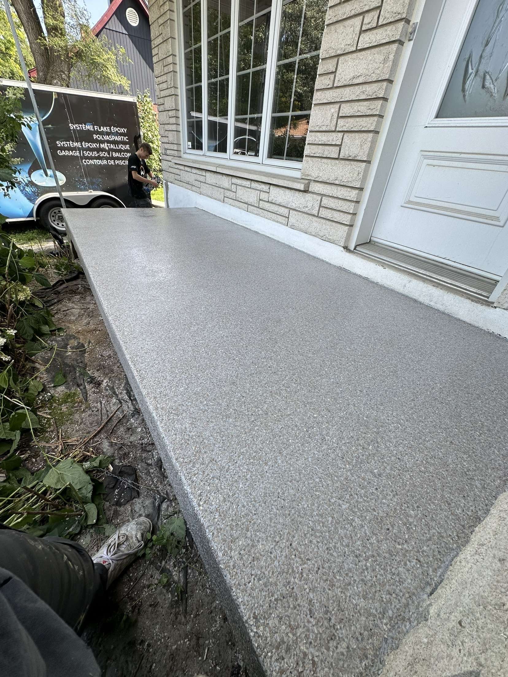 Une personne est assise sur un banc devant un bâtiment en briques.